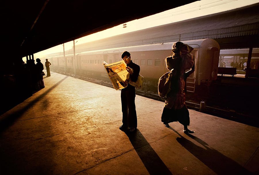 Indian train station at golden hour with travelers on the platform